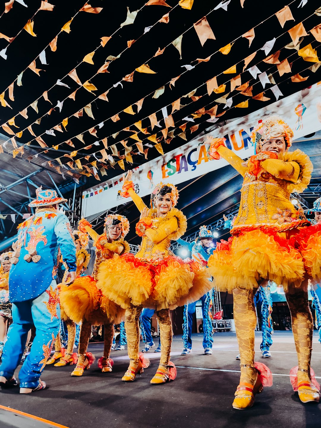 Dancers in colorful costumes perform on a stage at night.