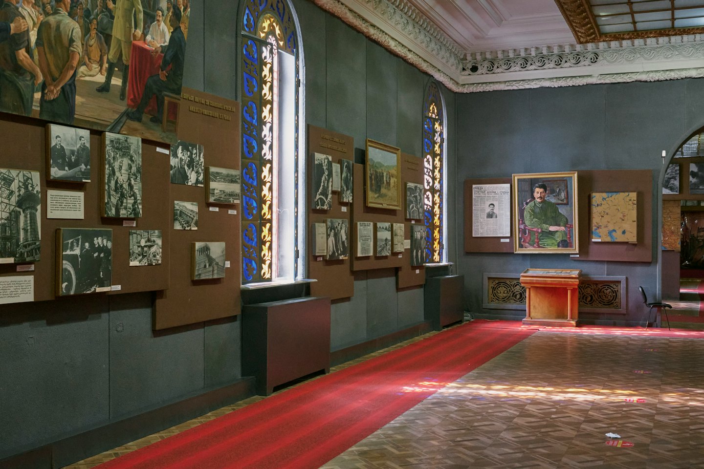 Historical museum gallery featuring exhibits and a red carpet runner.